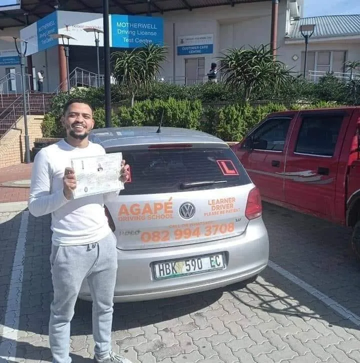 New Agapé driver proudly holding his licence beside the school’s branded car at Motherwell in Gqeberha